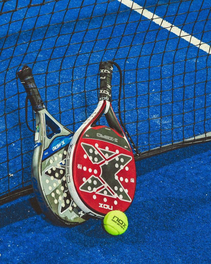 Two rackets and a ball resting on the net